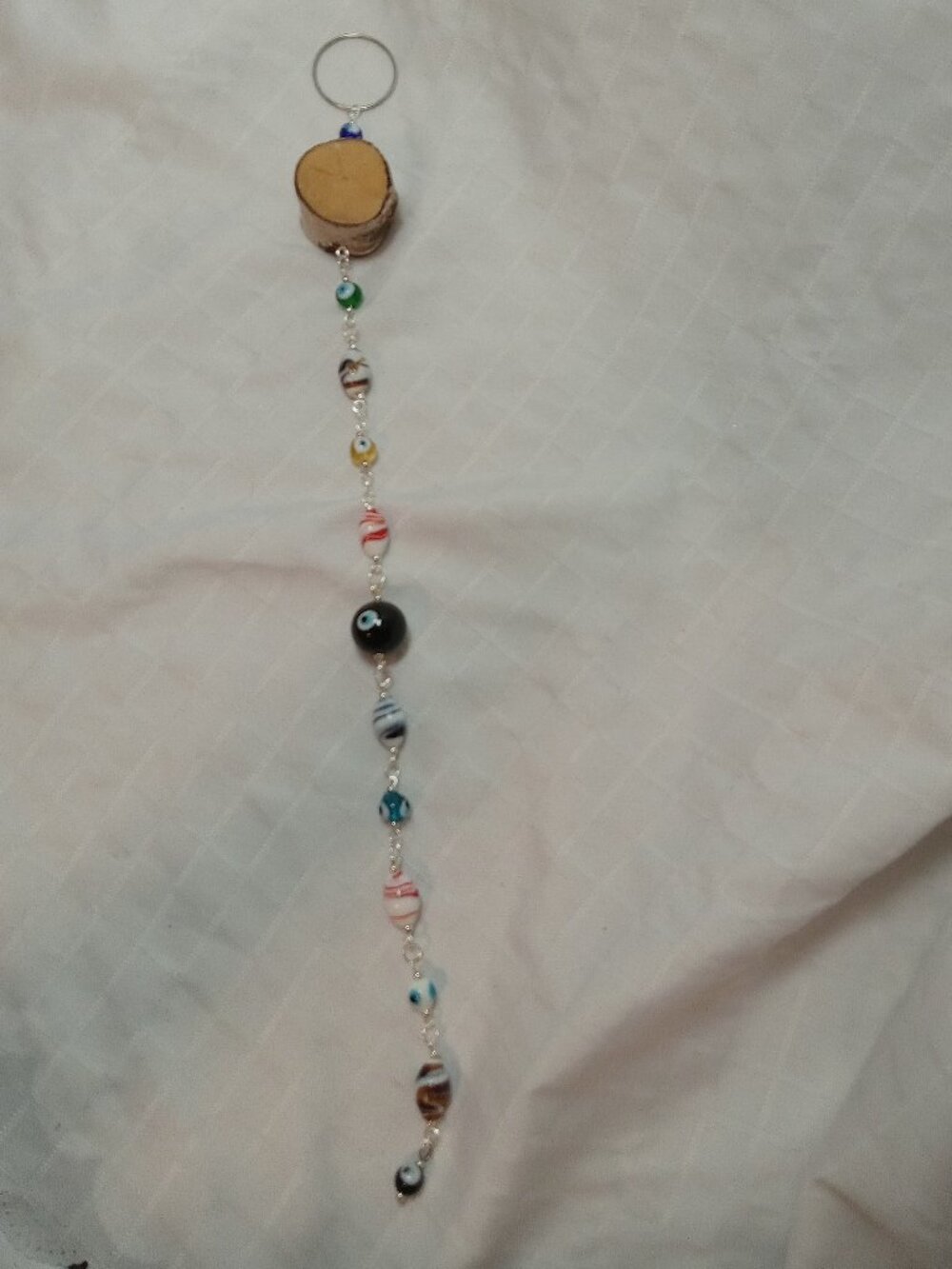 Handmade hanging decoration featuring handcrafted glass beads & wooden base